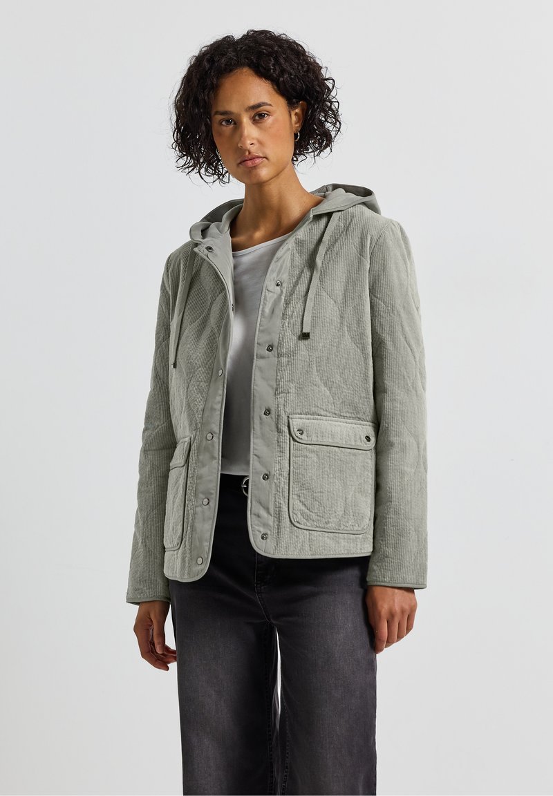 Light grey, quilted jacket with a hood, featuring snap buttons and two front pockets. Made of textured fabric, designed for casual wear.