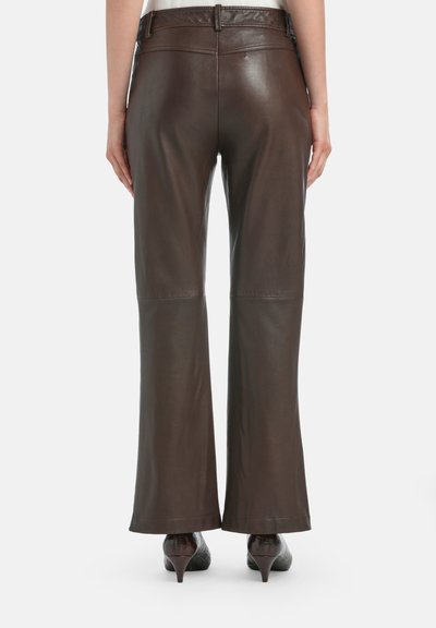 Bruine leren flare-pants met een gladde textuur, voorzien van stikdetails en een middelhoge taille. Draag ze met puntige hoge hakken.