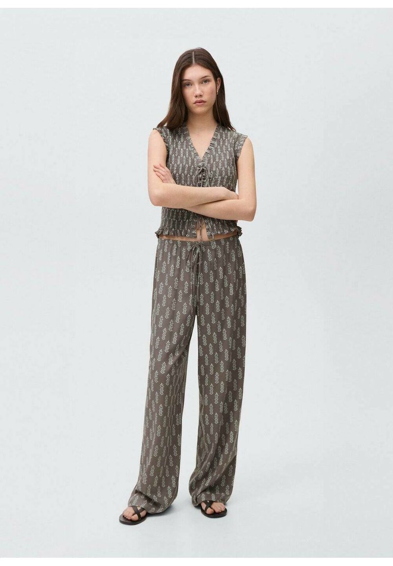 Brown patterned fabric loungewear set featuring a cropped top with a v-neck and drawstring waist pants. Soft texture with leaf design accents.
