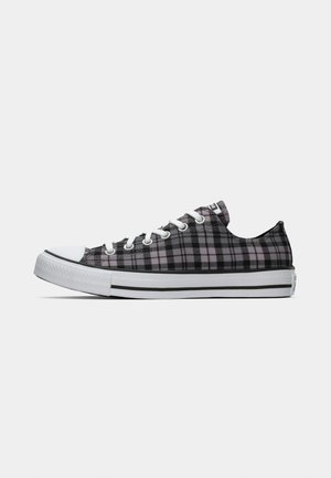 Zapatillas de lona a cuadros en negro y rosa con puntera de goma blanca, sistema de cordones y suela blanca con rayas negras. Diseño de caña baja.
