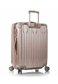 Valigia rigida di colore rosa metallico con righe verticali, manico telescopico e quattro ruote multidirezionali per una facile manovrabilità.