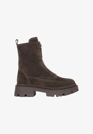 Braune Wildleder-Ankle Boots mit dicker Gummisohle, seitlichem Reißverschluss und Zugschlaufe an der Rückseite. Sie verfügen über eine glatte Textur und ein modernes Design.