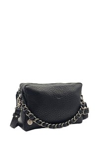 Sac à main en cuir noir texturé avec une chaîne en argent et une fermeture à glissière, petite étiquette ronde de la marque attachée à la chaîne.