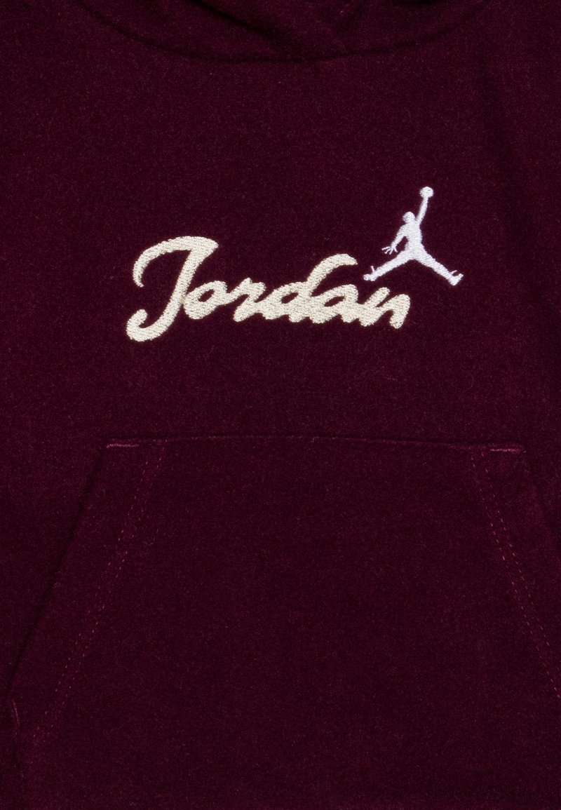 Burgunderfarbene Hoodie mit einer Fronttasche, besticktem "Jordan"-Logo in Weiß und einer Jumpman-Silhouette über dem Text. Weicher Stoff.