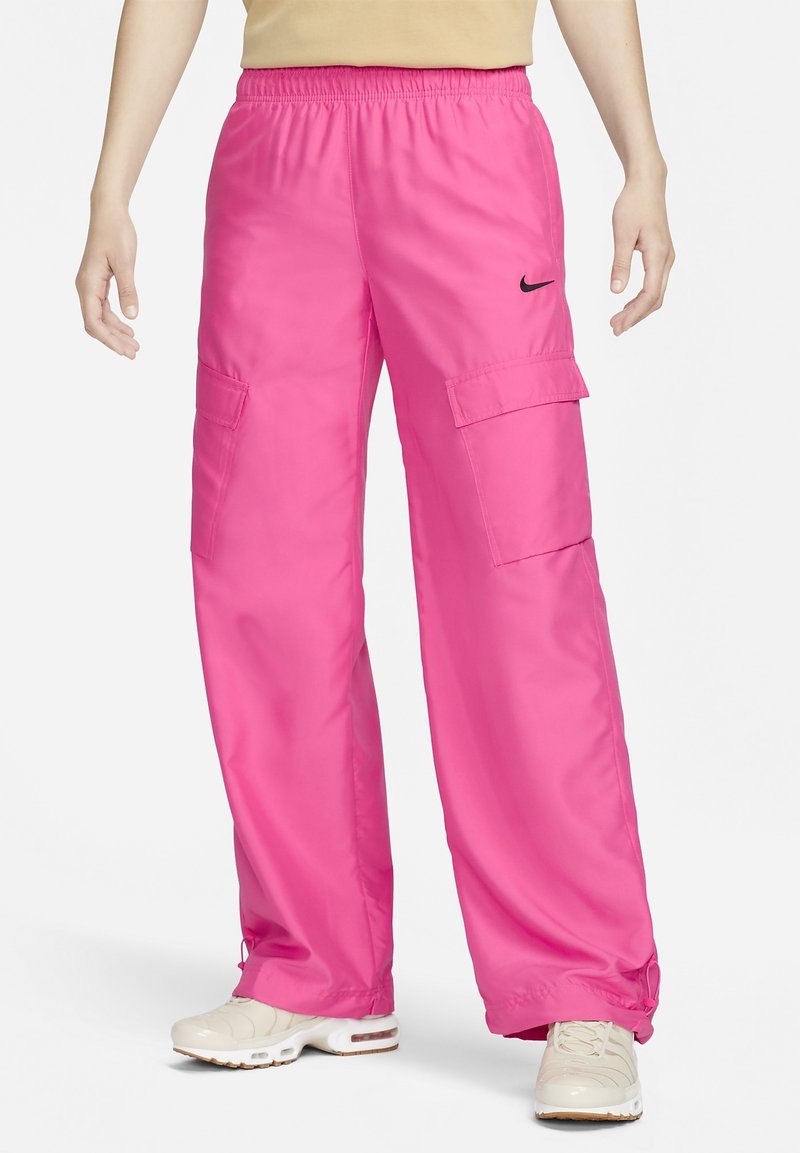 Rosa cargo-byxor med elastisk midja, två sidofickor och ett Nike-logotyp. Har en lös, bred ben-design och en slät, glänsande textur.