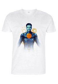 Vit bomulls t-shirt med ett grafiskt tryck av en figur i en blå kostym med en gul cirkel i mitten, omgiven av cirkulära mönster.