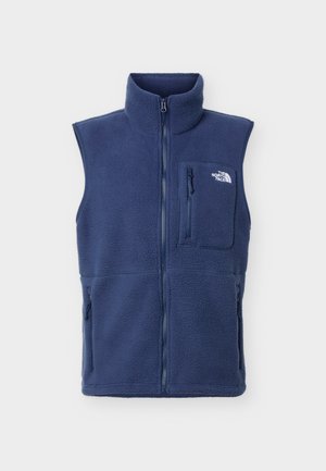 Gilet sans manches en polaire bleu marine avec fermeture éclair complète à l'avant, poche poitrine zippée, poches latérales, et logo The North Face sur la poche poitrine.