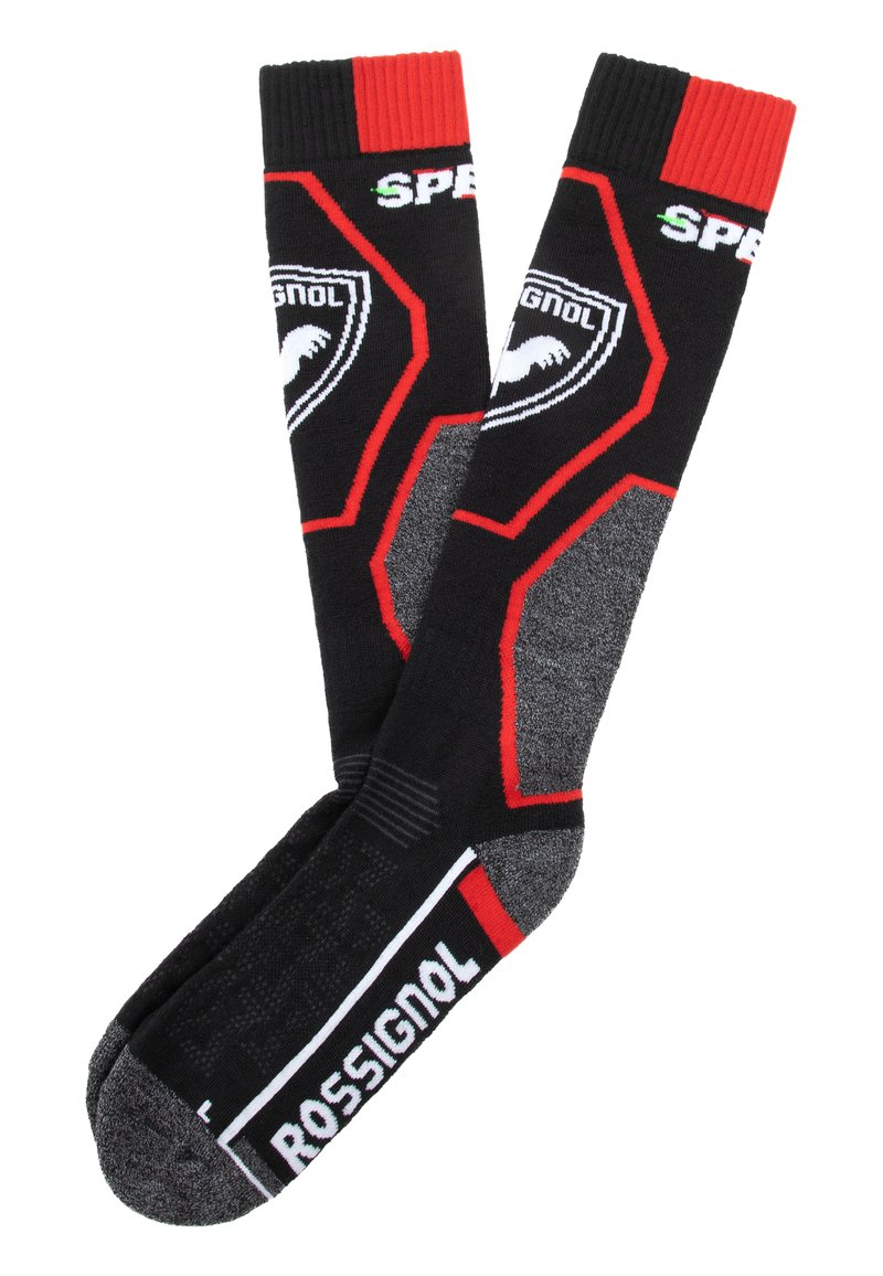 Calcetines de esquí negros con acentos rojos, que presentan un diseño texturizado, logotipos en blanco y una puntera reforzada. Parte superior acanalada para un ajuste seguro.