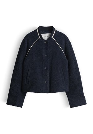 Veste en laine bleu marine à texture, avec boutons-pression, col côtelé rayé et poches avant en biais, étalée à plat sur fond blanc.