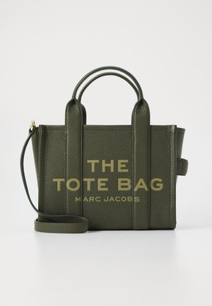 Oliven grøn tekstureret læder tote taske med dobbelt top hanke, aftagelig skulderrem og guldbogstaver: "THE TOTE BAG MARC JACOBS."