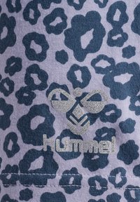 Lila tyg med ett mörkblått leopardmönster; har en silverlogotyp med "hummel" och en dekorativ bi-design.