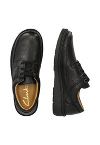 Chaussures en cuir noir avec une finition texturée, bout arrondi et lacets. Elles présentent une semelle intérieure rembourrée et une semelle en caoutchouc robuste.