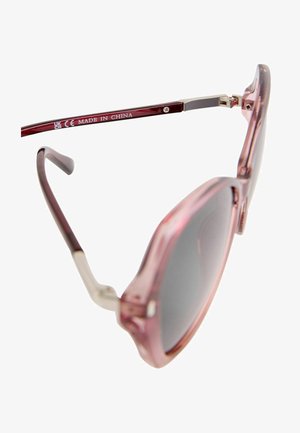 Roza prozorna sončna očala s širokim okvirjem, temno sivimi lečami in kovinskimi detajli na rokah. Oznaka "Made in China."