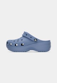 Világoskék gumi klumpa nyitott szellőzőlyukakkal, ívelt kialakítással, textúrázott talppal és állítható pánttal. Oldalán logóval ellátva.