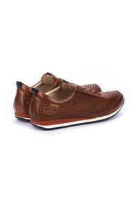 Scarpe in pelle marrone con design perforato, suola in gomma e intersuola bianca. Presentano un accento blu sul tallone e una parte anteriore senza lacci.