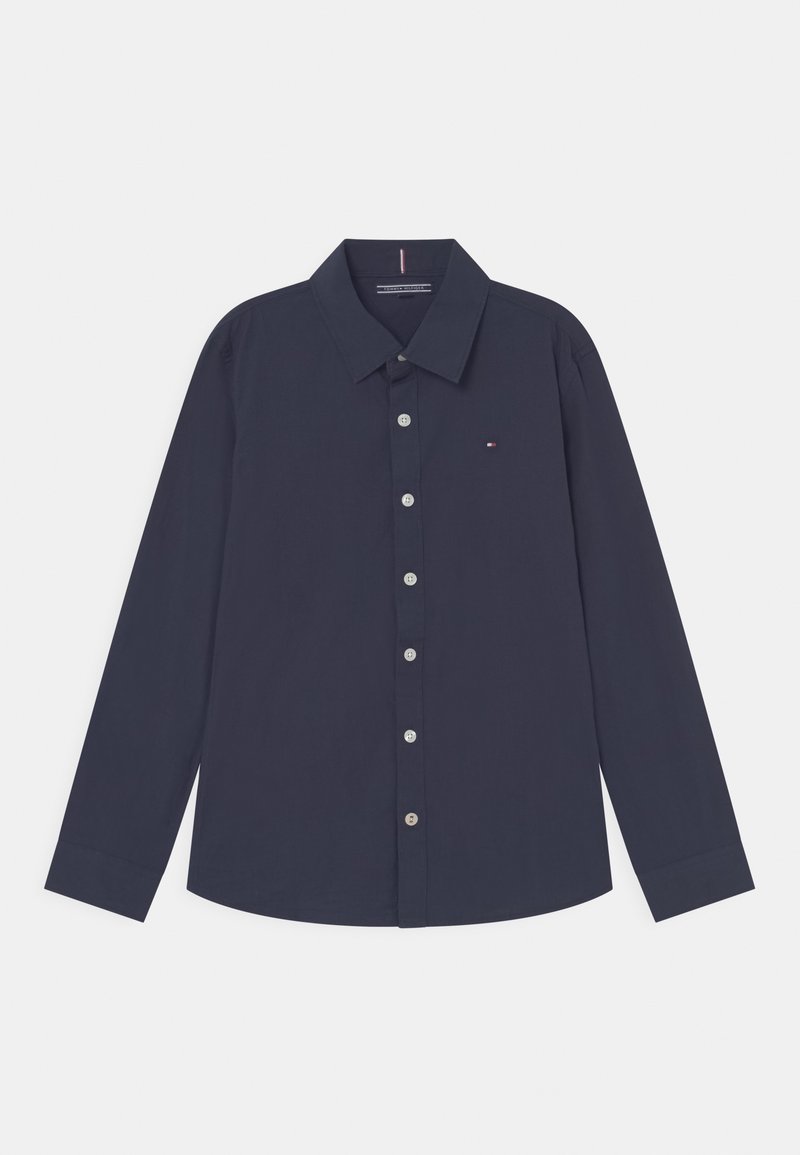 Donkerblauw overhemd met lange mouwen, knopen en kraag, met een klein rood, wit en blauw logo op de linkerborst.