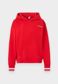 Sweat à capuche rouge avec logo Calvin Klein sur la poitrine et poignets rayés blancs sur les manches sur fond blanc.