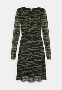 Musta mekko, jossa on vihreä tiikeri-raita kuvio; pitkät läpinäkyvät hihat; vartaloa myötäilevä yläosa; rypytetty yksityiskohta vyötäröllä; laskeutuva hame, jossa on kevyt hulmu.