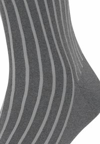 Calzini a righe grigie realizzati in morbido tessuto lavorato a maglia, con righe grigie scure e chiare alternate, una texture liscia e un design di lunghezza media.