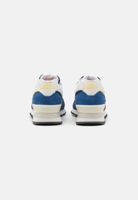 Paire de baskets New Balance en blanc, bleu et gris vues de dos sur un fond clair uni.