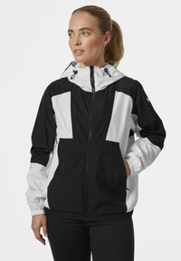 Zwart-witte windbreaker jas met ritssluiting aan de voorkant, elastische manchetten, twee zijzakken en een trekkoordcapuchon. Matte textuur, kleurblokontwerp.