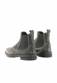 Stivali Chelsea in suede grigio con pannelli elastici ai lati, punta arrotondata e suola in gomma con texture. Linguette sul retro per una facile calzata.