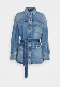 Jeans jakna s ovratnikom, sprednjim gumbom, dvema prsoma žepoma in pasom. Svetlo do srednje modra pranja z rahlim bledenjem.
