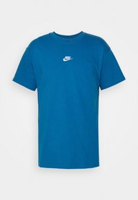 Modrá bavlněná tričko s klasickým kulatým výstřihem a krátkým rukávem. Malé bílé logo Nike tištěné na hrudi.