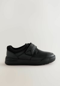 Baskets noires en matériau synthétique lisse, avec un col rembourré, une sangle ajustable, un bout arrondi et une semelle en caoutchouc avec des rainures horizontales.
