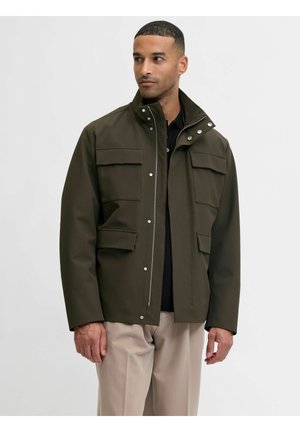 Olivno zeleni jopič iz gladkega, vodoodpornega blaga. Ima štiri velike žepe z poklopcem, zadrgo spredaj in gumbe na ovratniku.