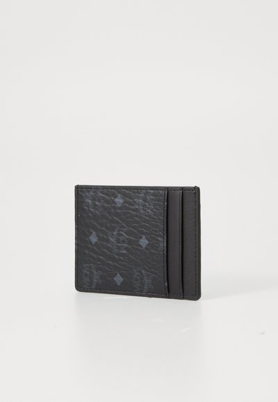 Svart lær kortholder med teksturert overflate, preget logo-mønster og flere kortrom. Kompakt design med en moderne finish.