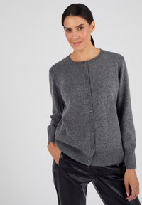 Cardigan en laine grise avec un col rond, fermeture par boutons à l'avant, poignets côtelés et une coupe légèrement ajustée. Présente une texture lisse et des accents subtils.
