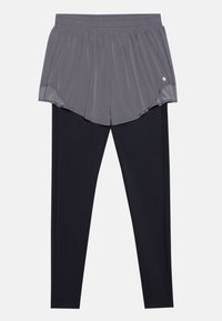 Harmaat kerroshousut mustien leggingsien päällä, joissa on kirjottu vyötärö. Kangas näyttää sileältä, ja saumojen kohdalla on tikattu yksityiskohtia.