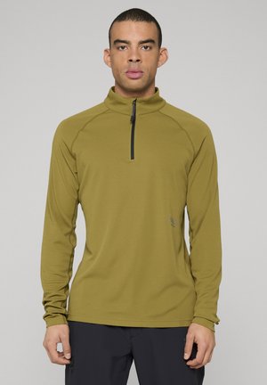 Długi rękaw w oliwkowej zieleni z kołnierzem na zamek do ćwiartki, teksturowana tkanina i subtelny detal logo z przodu.
