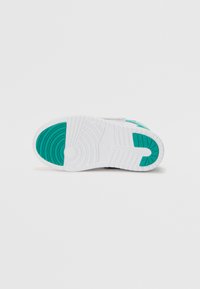 Sneaker sole in white rubber with green accents. Features a textured grip pattern and raised areas for traction. Rounded heel design.