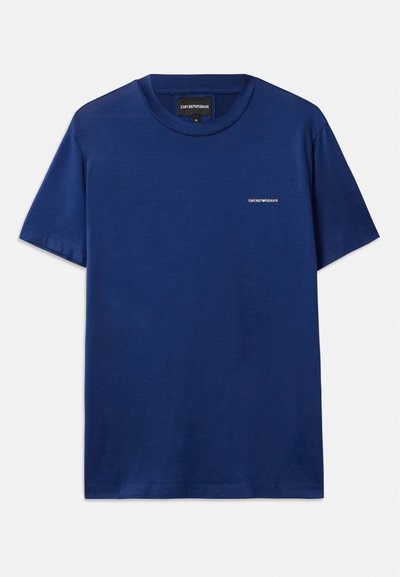 Tamsiai mėlynos spalvos marškinėliai, pagaminti iš minkštos medvilnės. Savybės: apykaklė su apvaliu iškirpimu ir trumpomis rankovėmis. Mažas logotipas ant krūtinės. Lygus paviršius.