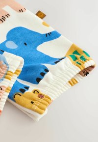 Baumwollshorts mit buntem Tierdruck, der blaue Elefanten, gelbe Löwen und rosa Akzente zeigt. Elastischer Bund mit gerafftem Design.