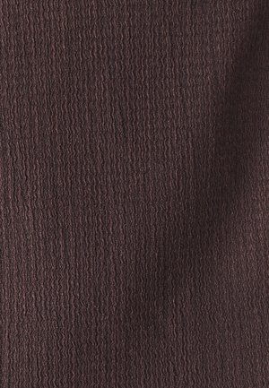 Rudas tekstūruotas audinys su banginiu raštu, rodantis įvairius tamsiai ir šviesiai rudos spalvos atspalvius, sukuria subtilų gelmės jausmą.