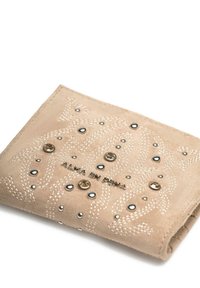 Portafoglio in suede beige con cuciture a zigzag, adornato da borchie rotonde nere e dorate, e con la scritta "ALMA EN PENA" in rilievo sulla parte anteriore.