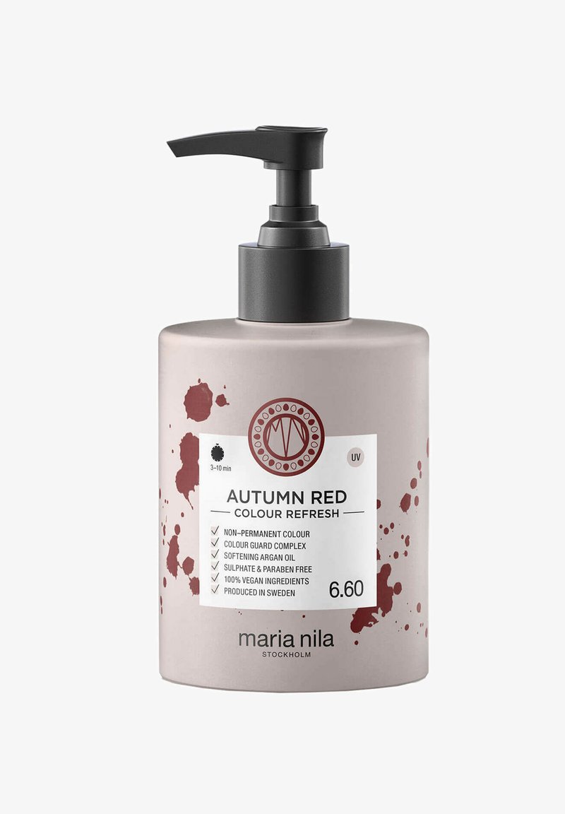 Pompbus met haarverfcrème in matte lichtroze, met een donkere accentpomp en een rood spetterdesign. Het etiket geeft de kleur en ingrediënten aan.