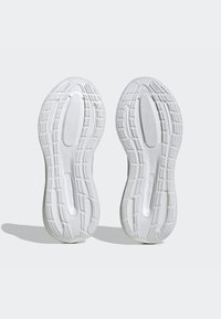 White athletic shoe soles featuring textured rubber grips, a smooth central section, and “CLOUDFOAM” branding along the side.
