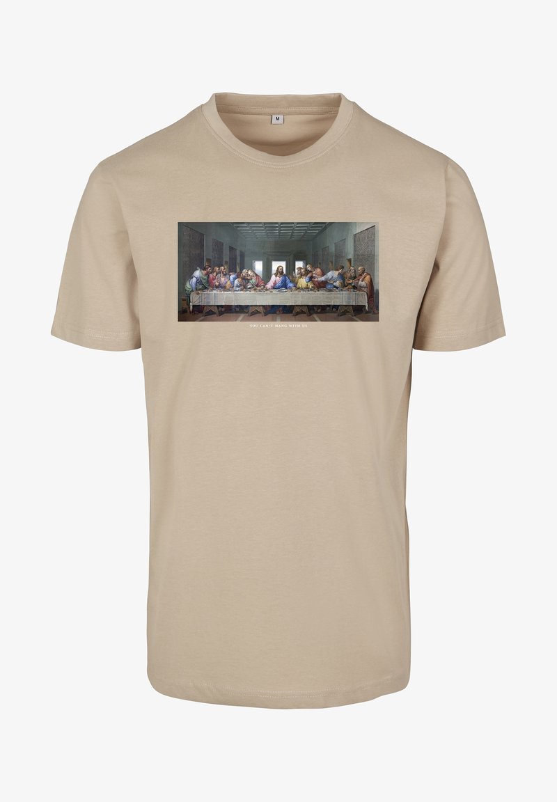 Beige katoenen t-shirt met een bedrukte afbeelding van de 'Laatste Avondmaal' en de tekst "JE KUNT NIET MET ONS MEESPELEN" onder de afbeelding.