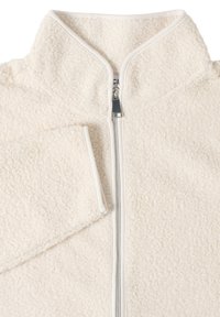 Veste en polaire crème avec une fermeture éclair sur toute la longueur à l'avant et des manches longues, présentant une surface en tissu texturé et en boucle.