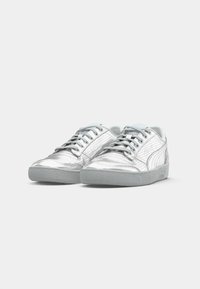 Et par sølvmetallic lave sneakers med grå snørebånd og teksturerede grå gummisåler på en helt hvid baggrund.