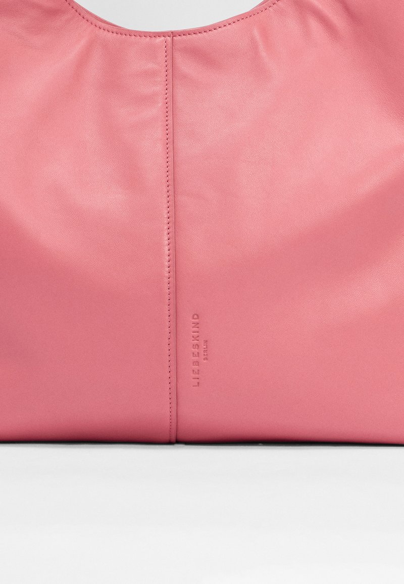 Rosa Lederhandtasche mit glatter Textur, runder Form und geprägtem Markenlogo; oberer Naht mit gerafftem Designdetail.