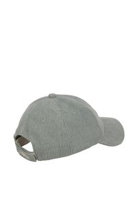 Zielona czapka z sztruksu z zakrzywionym daszkiem, teksturowanymi liniami i regulowanym paskiem z tyłu. Widoczna tylna metka akcentowa.