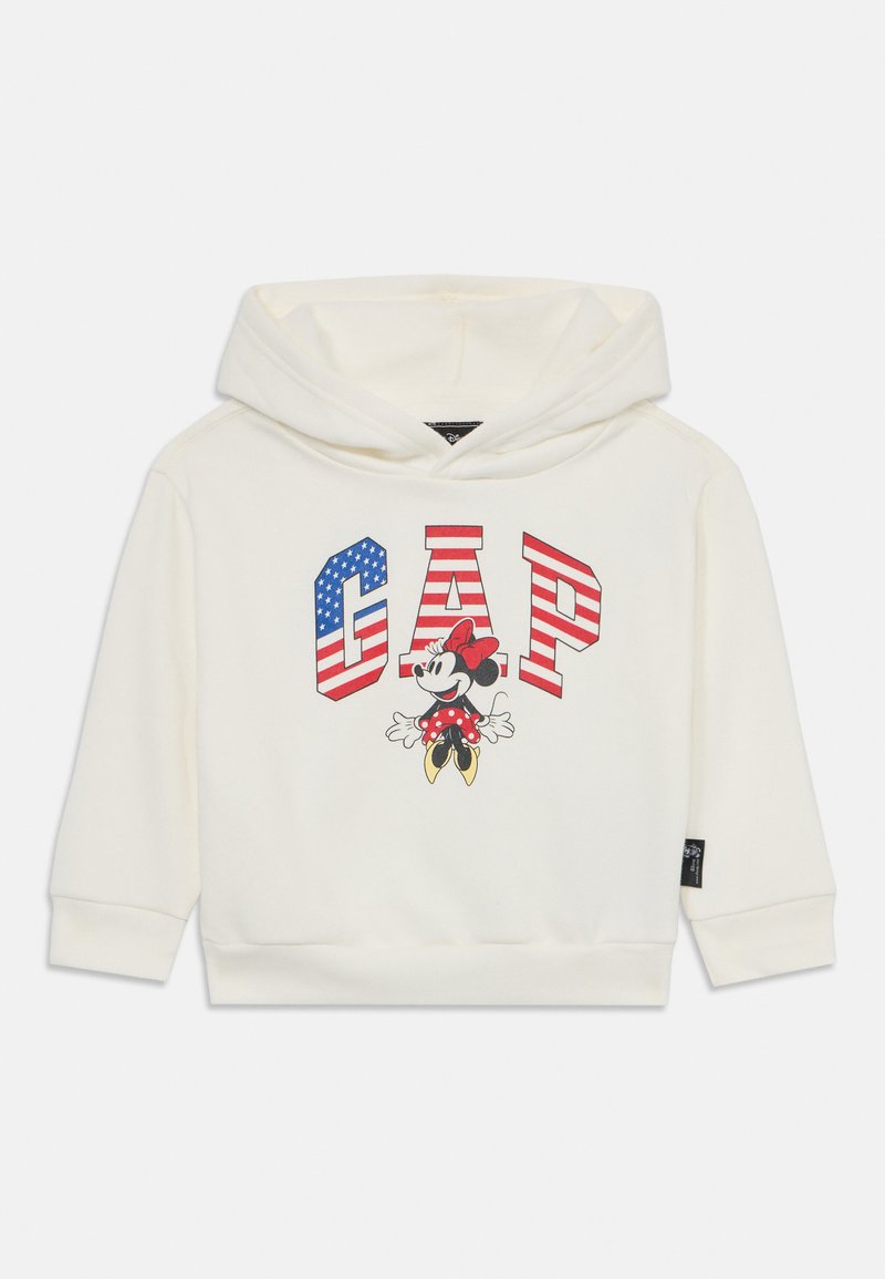 Sudadera blanca con un gran logo de "GAP" en rayas rojas y azules, junto a un gráfico de un personaje de dibujos animados con lunares.