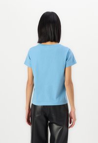 Ανοιχτό μπλε κοντομάνικο μπλουζάκι με στρογγυλή λαιμόκοψη, φτιαγμένο από μαλακό βαμβάκι, σχεδιασμένο με χαλαρή εφαρμογή και ίσια τελείωμα.