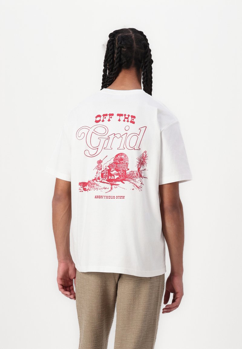 White cotton t-shirt featuring a red graphic print with the text "OFF THE Grid" and an illustration on the back. Short sleeves, crew neck.