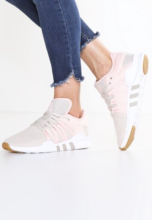 Chaussures de sport légères roses avec dessus en mesh, lacets beiges et semelle en caoutchouc gomme. Présentent trois bandes blanches sur le côté.